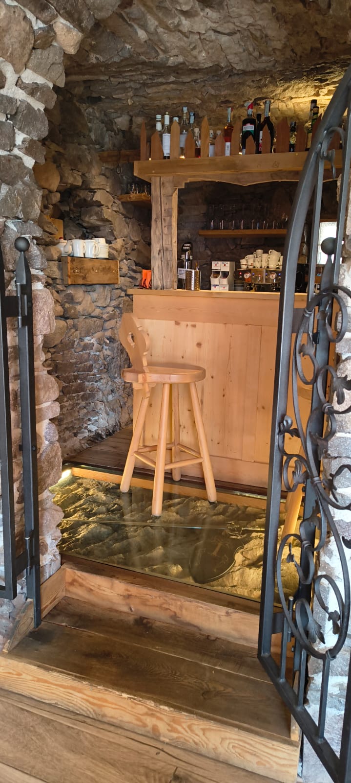 Bancone del bar in legno e pavimento in vetro sopra la pietra illuminata