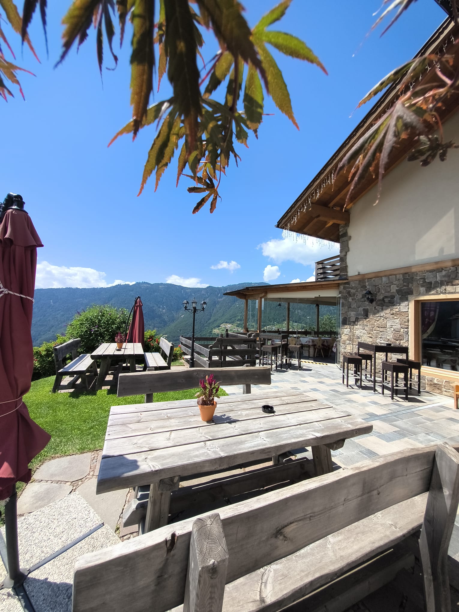 Aussenterrasse des Restaurants mit Tischen und Bergblick